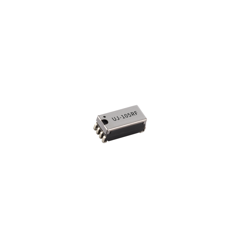 A small black integrated circuit chip from the U Series with silver pins on both sides, labeled UJ-10SRF on the top surface, likely used in Reed Relay applications, isolated on a white background. by Standex Detect