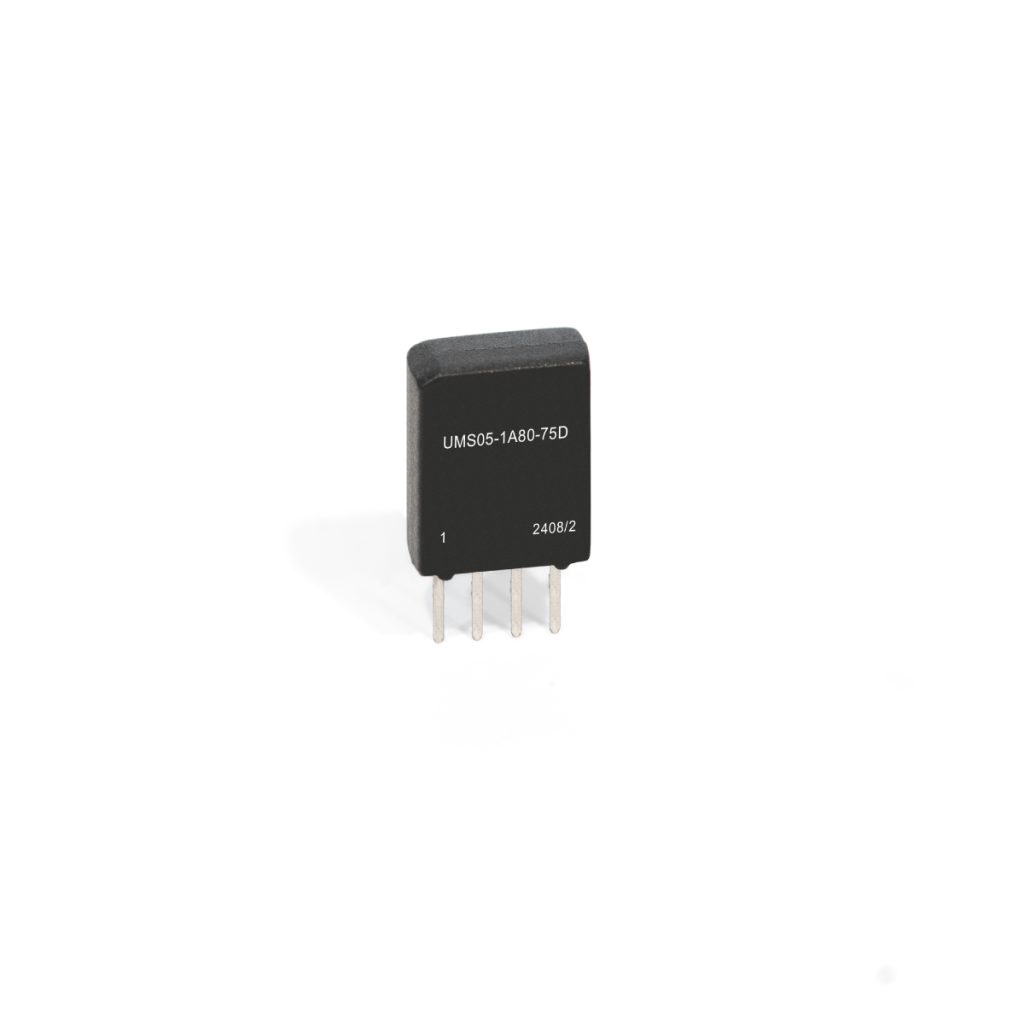 A small black Reed Relay electronic component from the UMS Series with four metal pins and the label UM505-1A80-75D 24082 printed on its front, standing upright on a white background. by Standex Detect