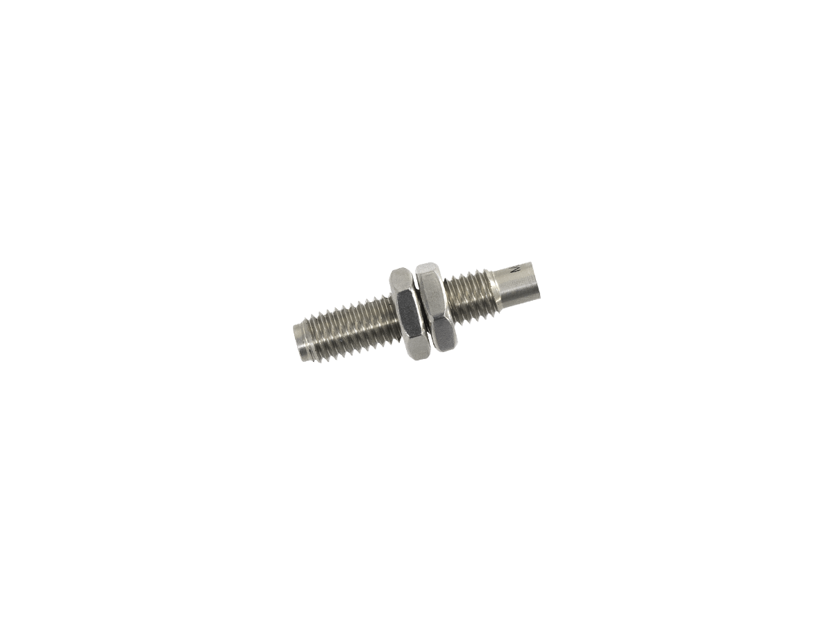 A small metal threaded M11S Series Magnet sensor or bolt with two hexagonal nuts, isolated on a white background. by Standex Detect