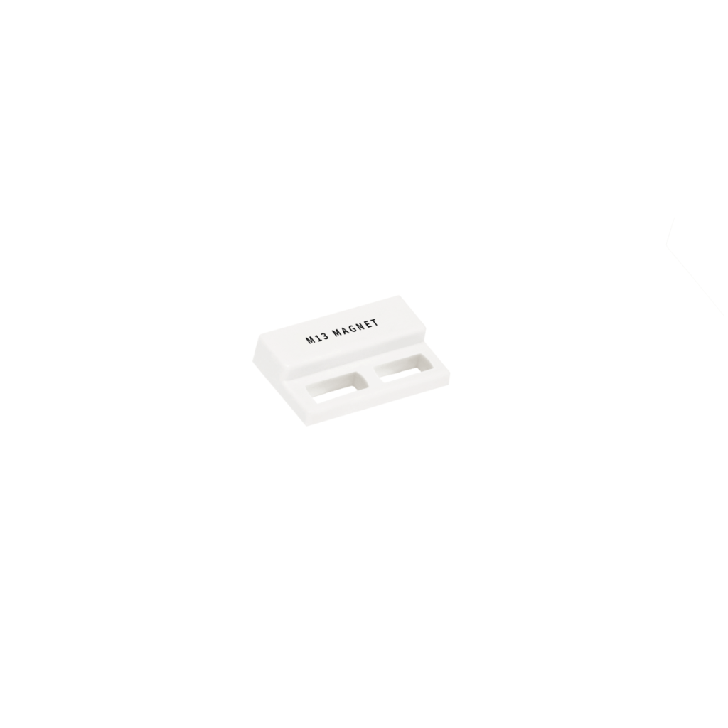 A small white rectangular M02 Series Magnet labeled M13 MAGNET, featuring two horizontal slots, placed on a plain white background. by Standex Detect