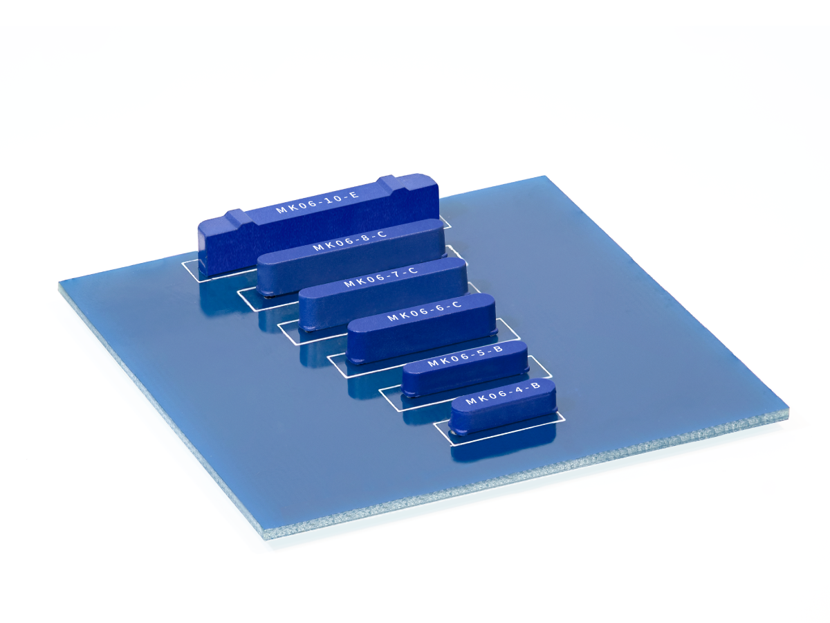 A blue square glass panel features six blue rectangular blocks, including the MK06 Series Reed Switch, each labeled with different codes and arranged in descending order of size, placed diagonally across the panel on a white background. by Standex Detect