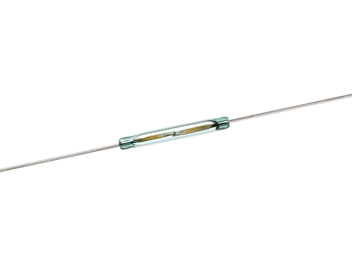A cylindrical glass ORD2210 Series Reed Switch with two metal wires extending from each end, shown on a white background. The switch’s inner contacts are visible through the transparent casing. by Standex Detect